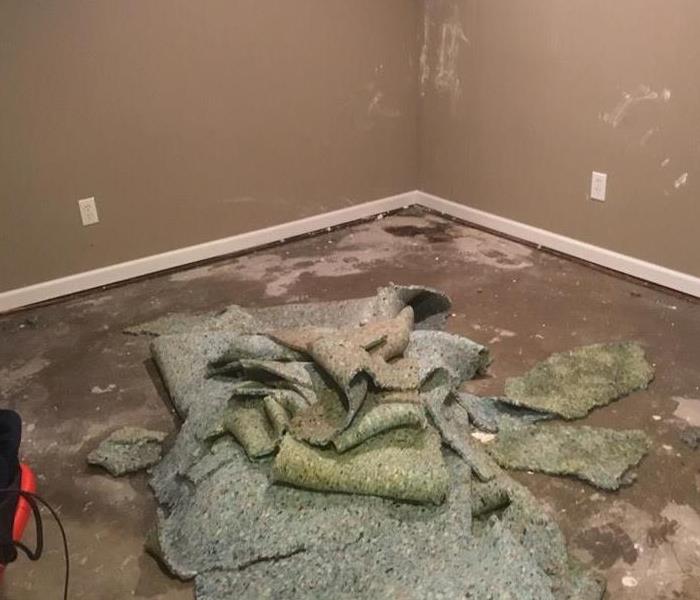 a room with the carpeting pulled back